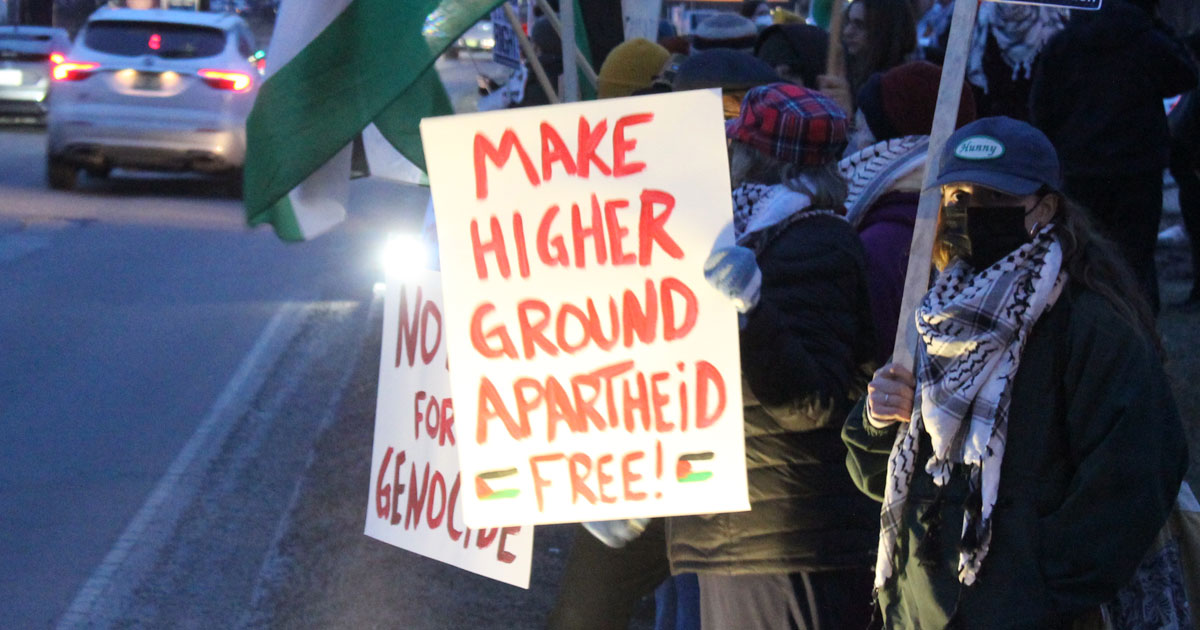 Protest sign reading Make Higher Ground Apartheid Free
